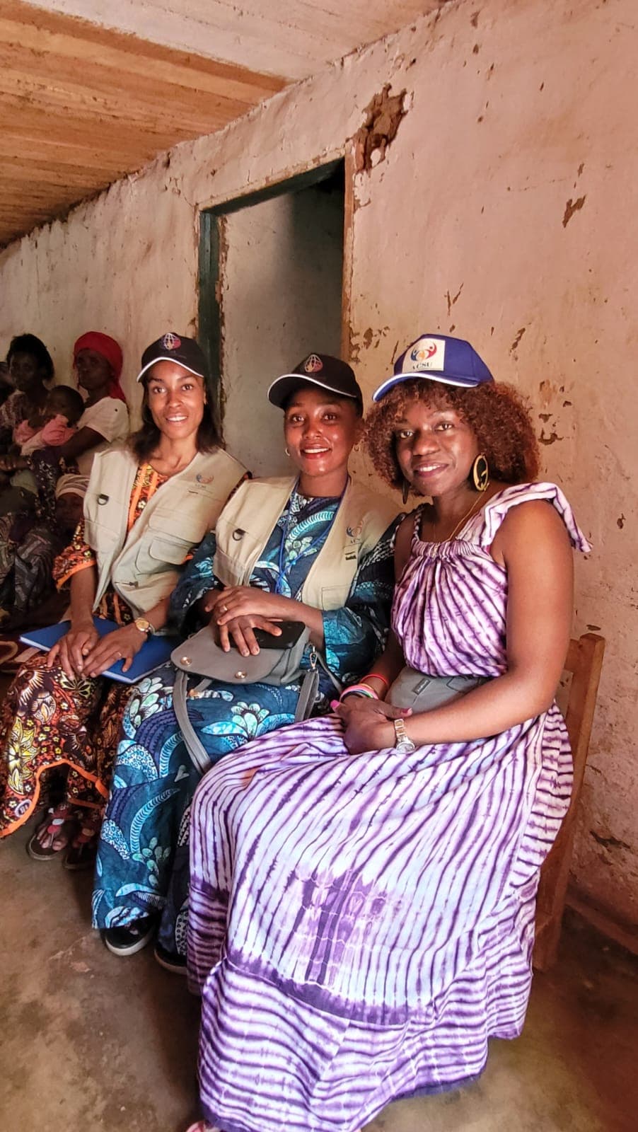 Ehrenamtliche und Frauen mit ACSU-Kappen im Ostkongo bei einem Frauen-Empowerment-Treffen