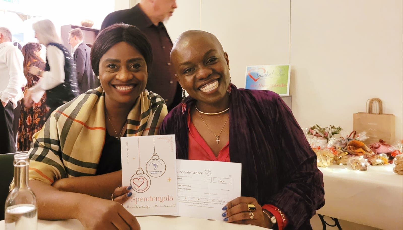 Zwei Frauen der Kette der Solidarität e.V. mit dem Spendencheck und der Gala-Programmkarte auf der Spendengala am 12. Dezember 2025 in Gevelsberg